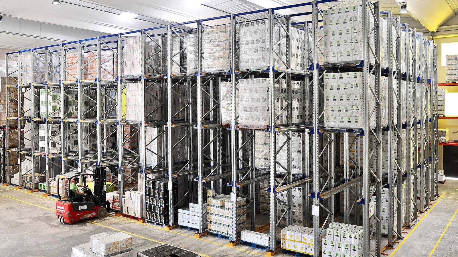 Forklift operating inside a high-density drive-in pallet racking lane